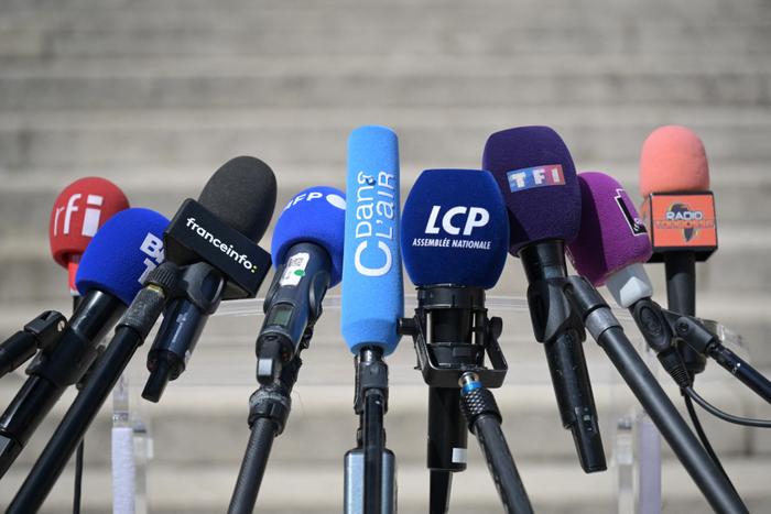 Cette photographie montre des microphones de médias, notamment RFI, BFMTV, franceinfo, AFP, CDanslAir, LCP, TF1, France Culture, installés pour les déclarations à la presse à l'Assemblée nationale à la suite du second tour des élections législatives, le 10 juillet 2024. 