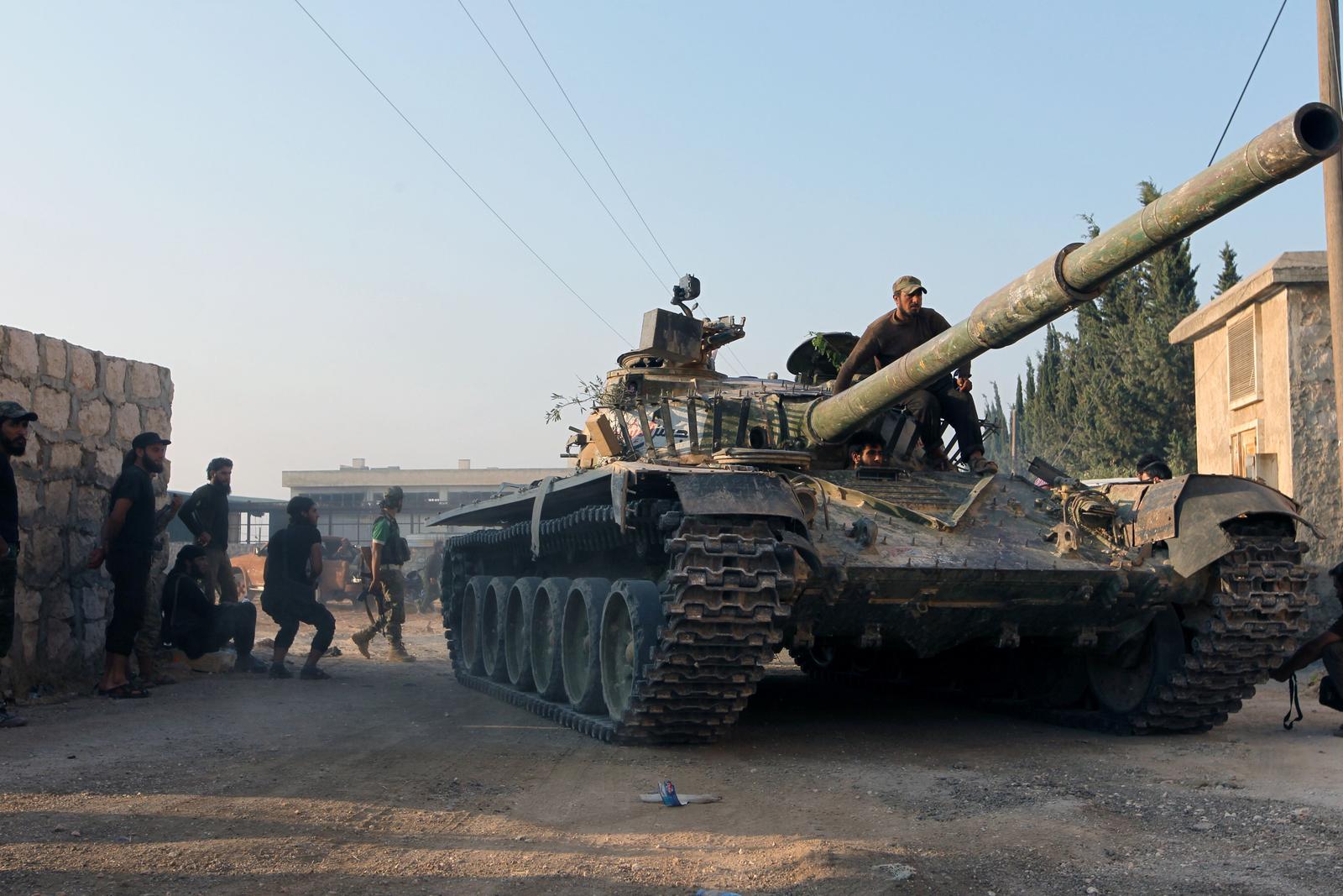 Des combattants rebelles syriens manœuvrent un tank dans Alep.