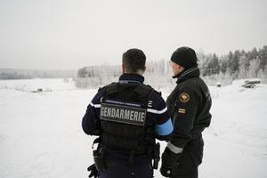 Un agent de Frontex et un garde-frontière finlandais se tiennent près du poste frontière fermé de Vaalimaa, entre la Finlande et la Russie, le 7 décembre 2023.