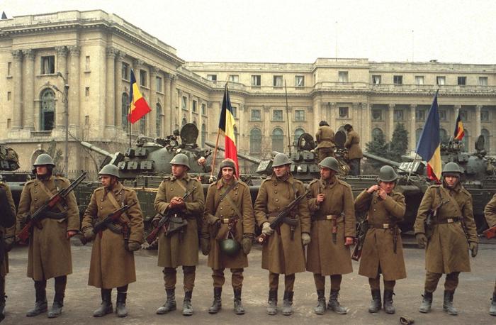 Des soldats de l'armée roumaine gardent l'entrée du Comité central, le 26 décembre 1989 à Bucarest, un jour après l'exécution de Nicolae Ceaucescu et de sa femme Elena, le 25 décembre 1989.