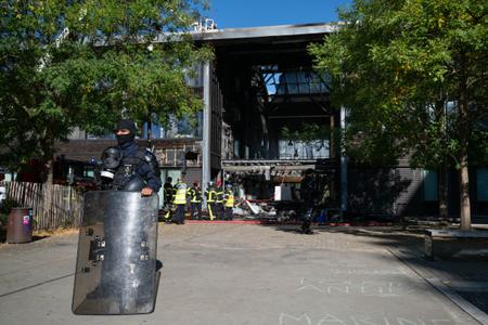 Un agent de sécurité observe les pompiers démanteler le hall d'entrée endommagé du lycée Nelson Mandela à Nantes, dans l'ouest de la France. Un incendie criminel a ravagé le hall de l'établissement, alors bloqué par des élèves.