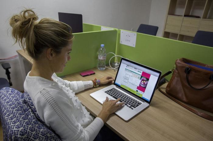 Une femme travaille sur un ordinateur portable dans un espace de coworking. (Image d'illustration)
