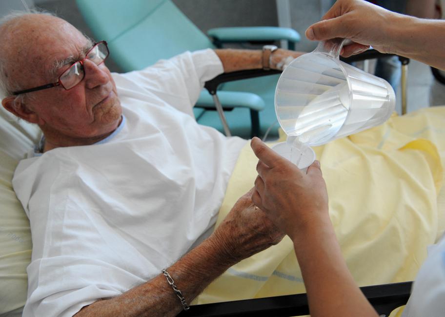 Une infirmière sert de l'eau à un patient au service des urgences de l'hôpital Toulouse-Purpan, à Toulouse.