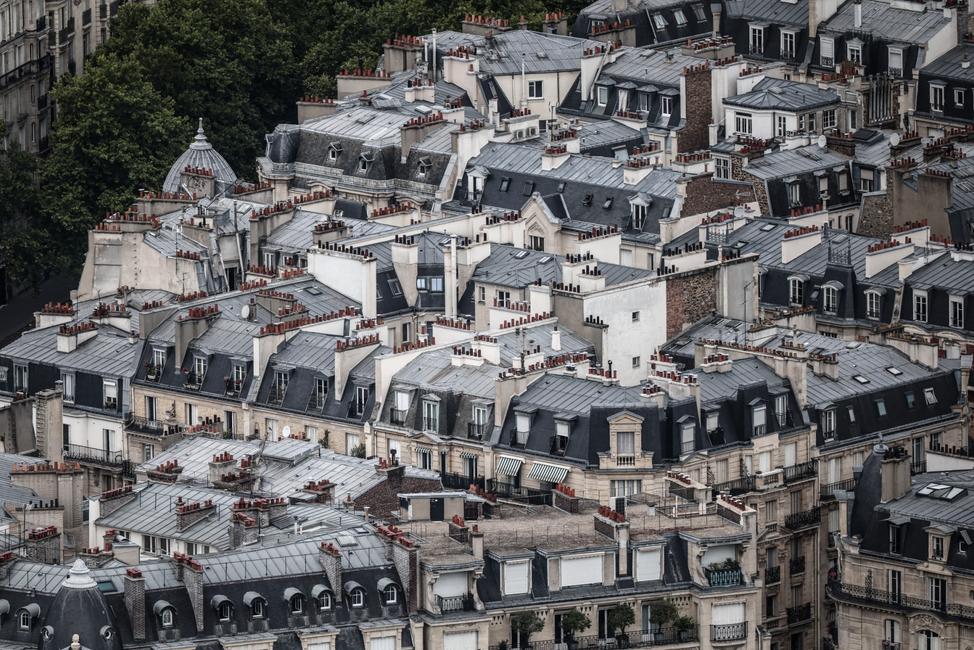 Cette photographie montre les toits en zinc de Paris vus du toit de la tour Montparnasse, le 14 juillet 2025.