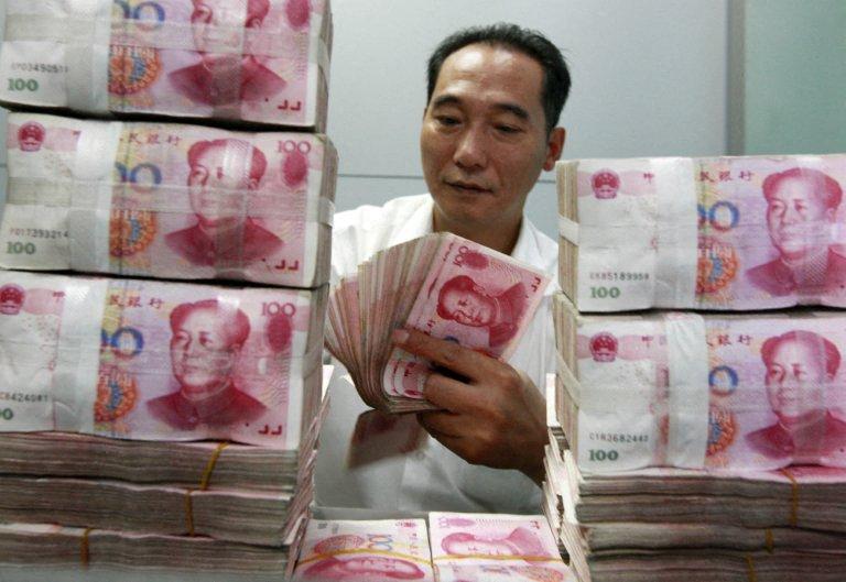 Un employé de banque chinois comptant des liasses de billets de 100 yuans dans une banque de Huaibei, dans la province d'Anhui, en Chine orientale.