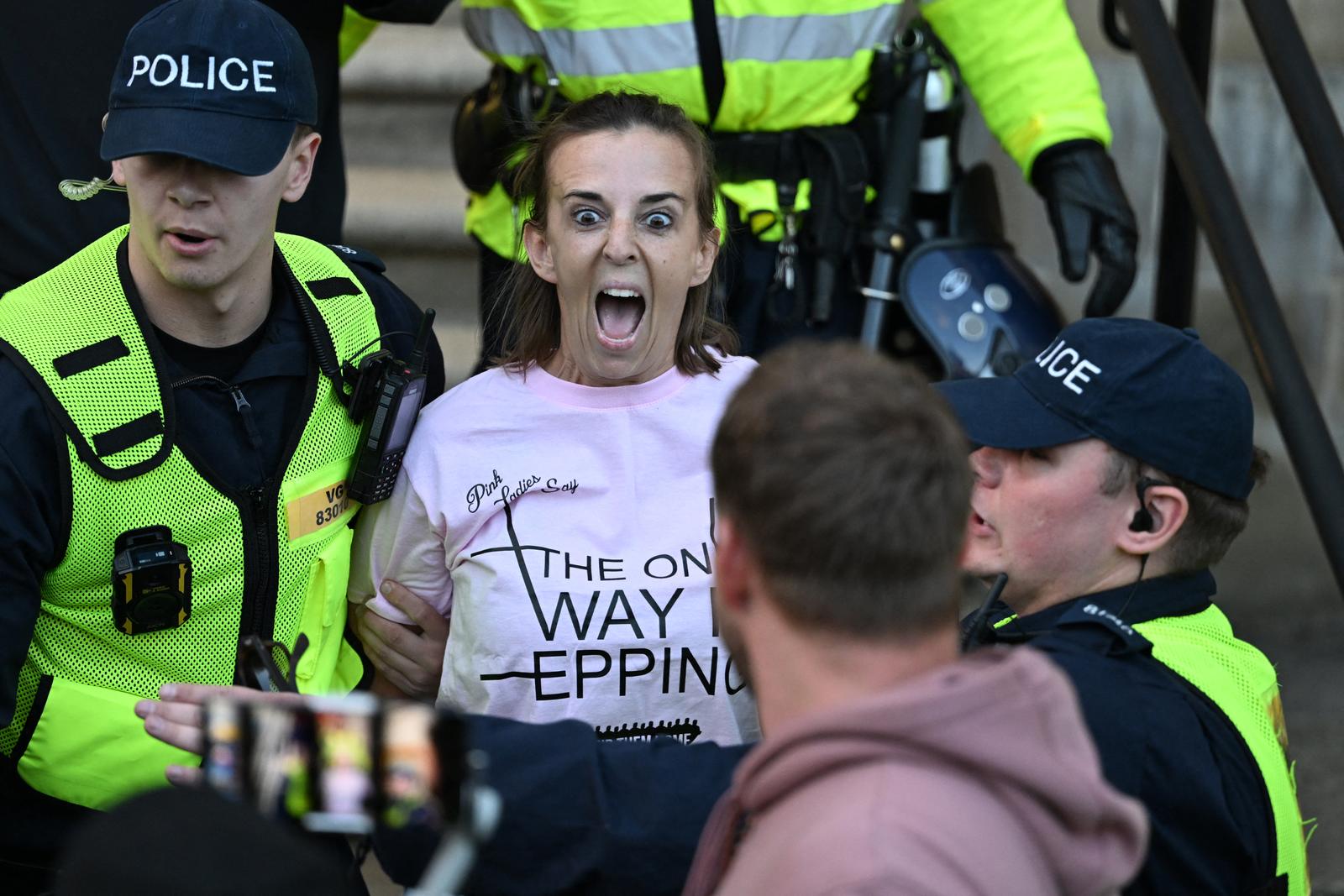 Une manifestante est arrêtée par la police devant les bureaux du conseil municipal d'Epping, après une marche depuis l'hôtel Bell, qui héberge des demandeurs d'asile au nord-est de Londres, le 31 août 2025. Le 29 août, une cour d'appel britannique a annulé une décision de première instance interdisant temporairement l'utilisation de l'hôtel touché par les manifestations pour héberger des demandeurs d'asile, une victoire majeure pour le gouvernement. (Photo de Chris J Ratcliffe / AFP)