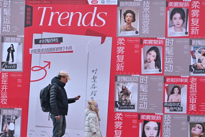 Des gens passent devant une publicité pour l'application chinoise de réseautage social et de commerce électronique Xiaohongshu, également connue sous le nom de RedNote, dans un centre commercial de Pékin le 15 janvier 2025.