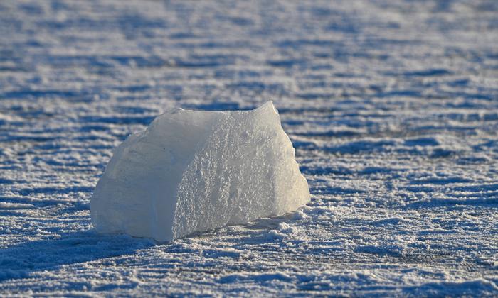 Un iceberg solitaire reposant sur une mer gelée à Helsinki, en Finlande, illustrant la beauté sereine de l'hiver.