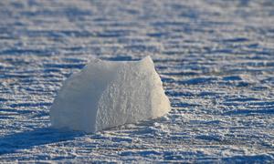 Un iceberg solitaire reposant sur une mer gelée à Helsinki, en Finlande, illustrant la beauté sereine de l'hiver.