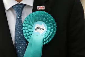 Un membre du parti Reform UK attend l'arrivée de Nigel Farage, le chef du parti, devant l'hôtel de ville de Havering, au lendemain des élections locales dans l'est de Londres, le 8 mai 2026.