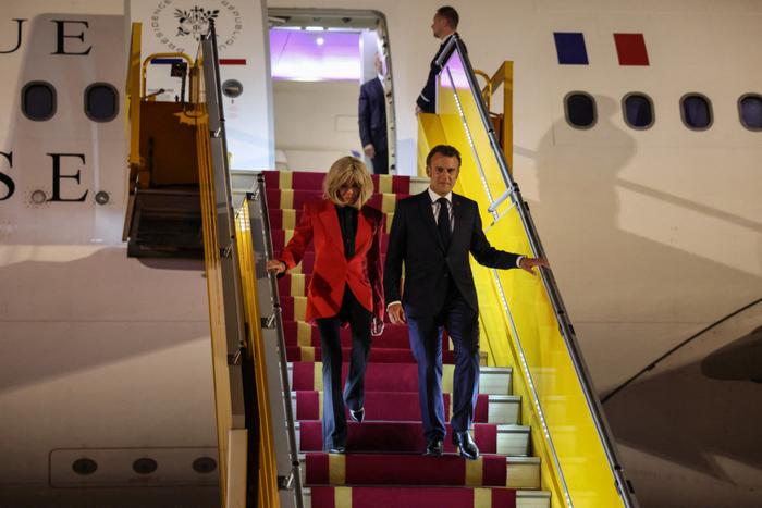 Le président français Emmanuel Macron et son épouse Brigitte Macron descendent de l'avion à leur arrivée à l'aéroport international de Noi Bai à Hanoï, le 25 mai 2025.