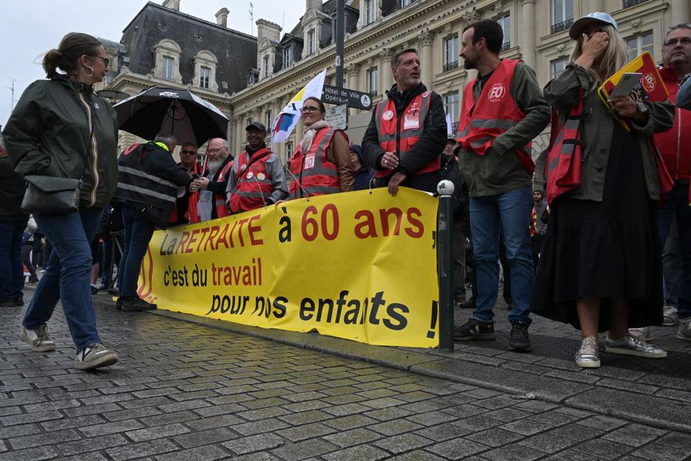Des manifestants brandissent une banderole lors d'une manifestation contre la réforme des retraites à Rennes, dans l'ouest de la France, le 5 juin 2025. 