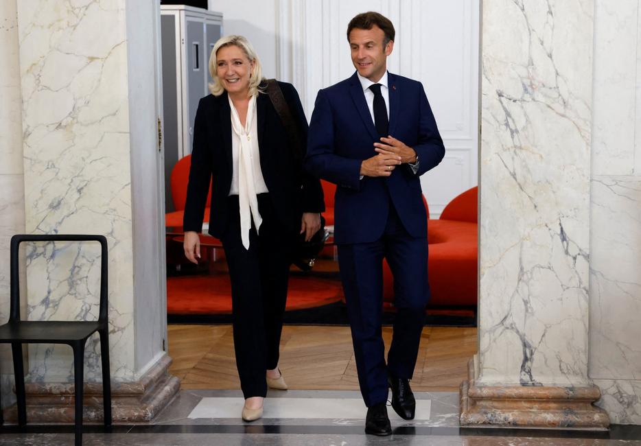 Marine Le Pen, dirigeante du Rassemblement national, est escortée par le président français Emmanuel Macron après des entretiens au palais de l'Élysée, à Paris, le 21 juin 2022, deux jours après les élections législatives françaises.