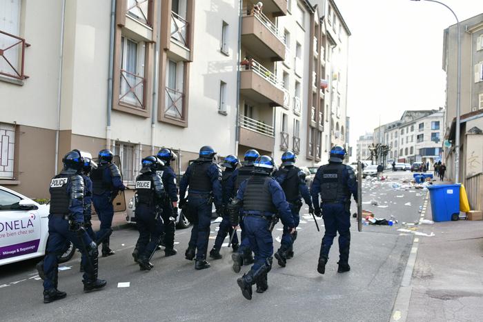 Des policiers anti-émeute patrouillent dans une rue de Limoges.