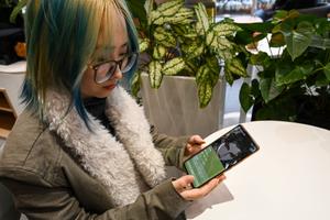 Une jeune femme dans un café de Pékin, en train de présenter son petit ami virtuel sur Wantalk, un chatbot d'intelligence artificielle créé par la société technologique chinoise Baidu.