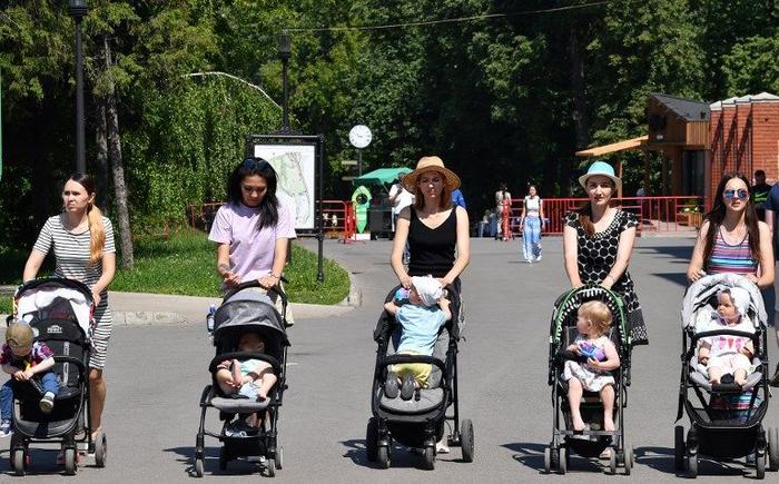 Des mères de famille dans un parc avec leurs enfants.