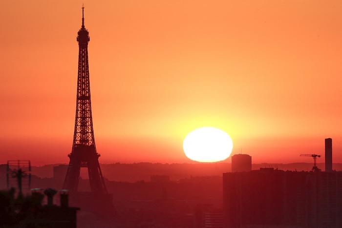 Le soleil se lève sur la tour Eiffel à Paris le 1er juillet 2025, alors que la ville est en alerte rouge en raison des fortes chaleurs.