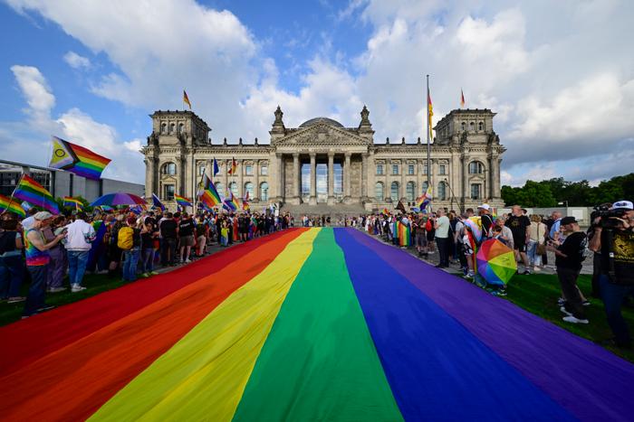 Un drapeau arc-en-ciel de 400 m² flotte sur la pelouse devant le Reichstag, à la veille du Christopher Street Day de Berlin, le 25 juillet 2025.