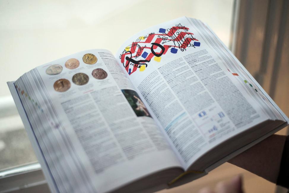 Une femme tient un exemplaire ouvert de la nouvelle édition du dictionnaire français « Petit Larousse », à Paris.