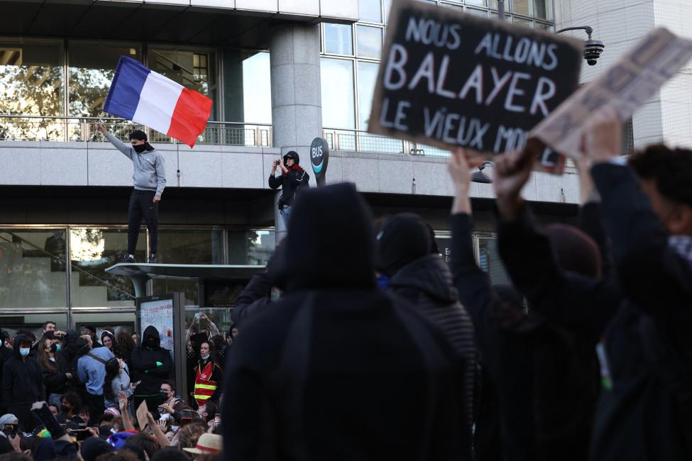 Un manifestant brandit le drapeau français lors d'une manifestation de lycéens place de la Bastille, à Paris, le 8 octobre 2026, dans le cadre d'un mouvement de protestation national contre les conditions d'apprentissage.