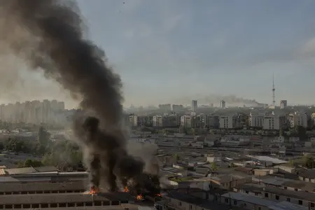 De la fumée s'élève de différents endroits endommagés lors de frappes de missiles et de drones russes à Kiev, le 2 juin 2026.