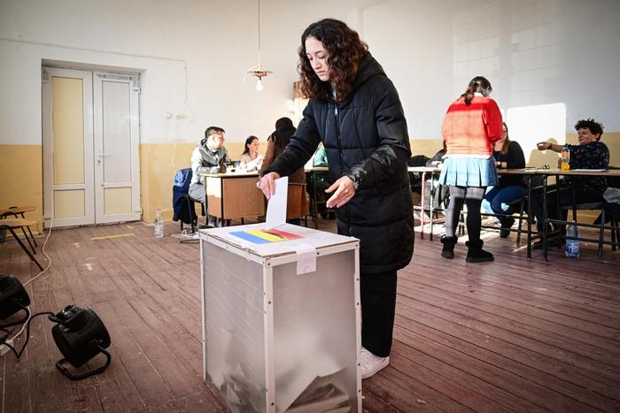 Une jeune femme vote dans un bureau de vote du village de Nuci, en Roumanie, le 24 novembre 2024.