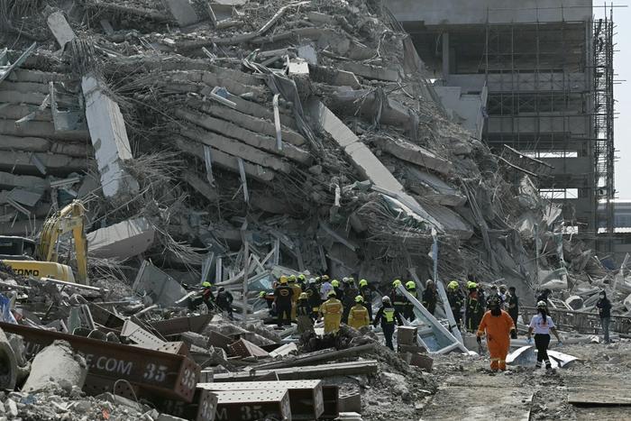 Des équipes de secours sont vues sur un chantier de construction où un bâtiment s'est effondré à Bangkok le 28 mars 2025, après un tremblement de terre.