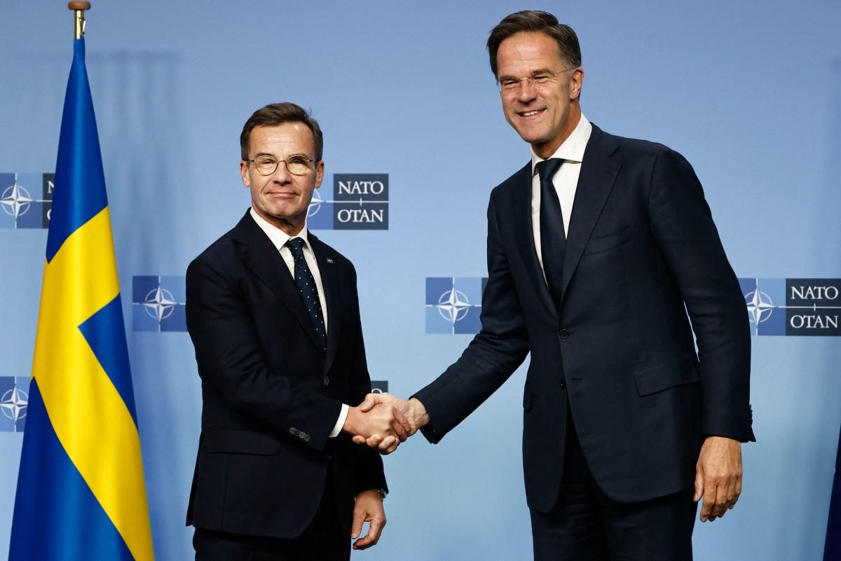 Le secrétaire général de l'OTAN Mark Rutte (à droite) salue le premier ministre suédois Ulf Kristersson lors de leur rencontre au siège de l'OTAN à Bruxelles, le 16 octobre 2024.