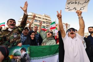 Des Iraniens brandissent des drapeaux et des pancartes lors d'un rassemblement de protestation contre l'attaque américaine contre l'Iran sur la place Enghelab à Téhéran, le 22 juin 2025.