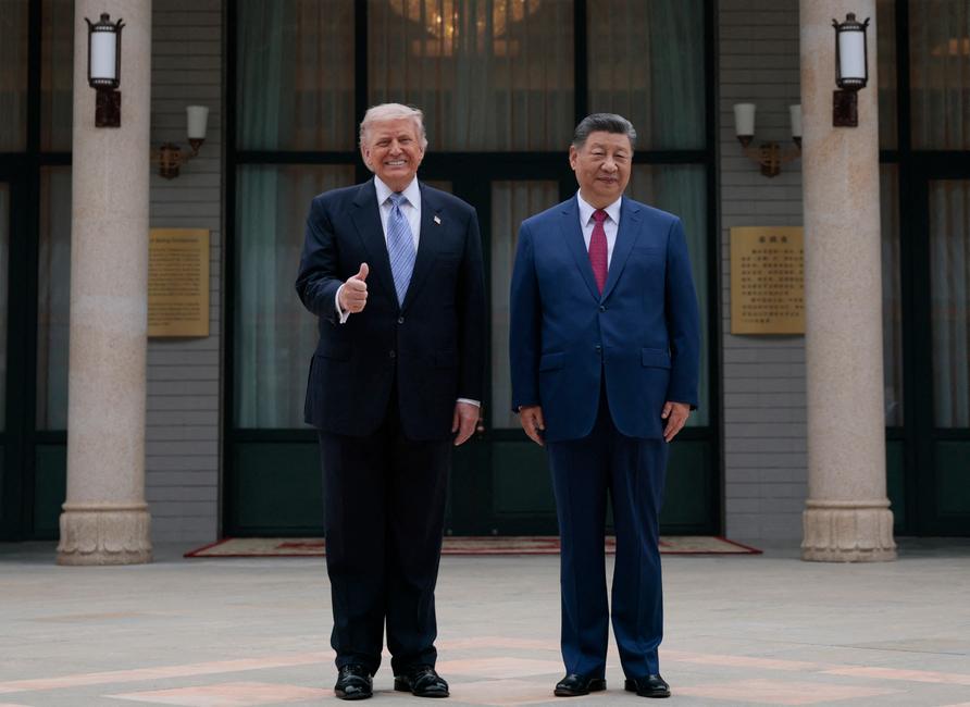 Le président américain Donald Trump pose pour des photos avec le président chinois Xi Jinping lors d'une visite au jardin Zhongnanhai à Pékin le 15 mai 2026.