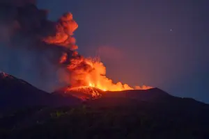 Une photographie prise le 5 juillet 2026 montre de la lave s'écoulant et de la fumée s'élevant du cratère lors d'une éruption du volcan Etna, en Sicile.