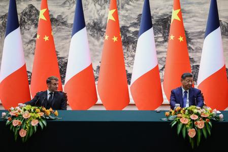 Le président chinois Xi Jinping et le président français Emmanuel Macron font une déclaration conjointe à la presse à l'issue de leurs réunions et d'une cérémonie de signature d'accords au Palais de l'Assemblée du Peuple à Pékin, le 4 décembre 2025.