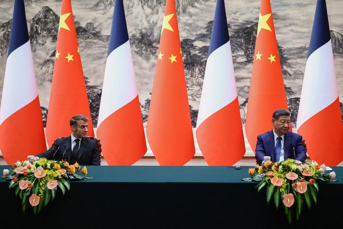 Le président chinois Xi Jinping et le président français Emmanuel Macron font une déclaration conjointe à la presse à l'issue de leurs réunions et d'une cérémonie de signature d'accords au Palais de l'Assemblée du Peuple à Pékin, le 4 décembre 2025.