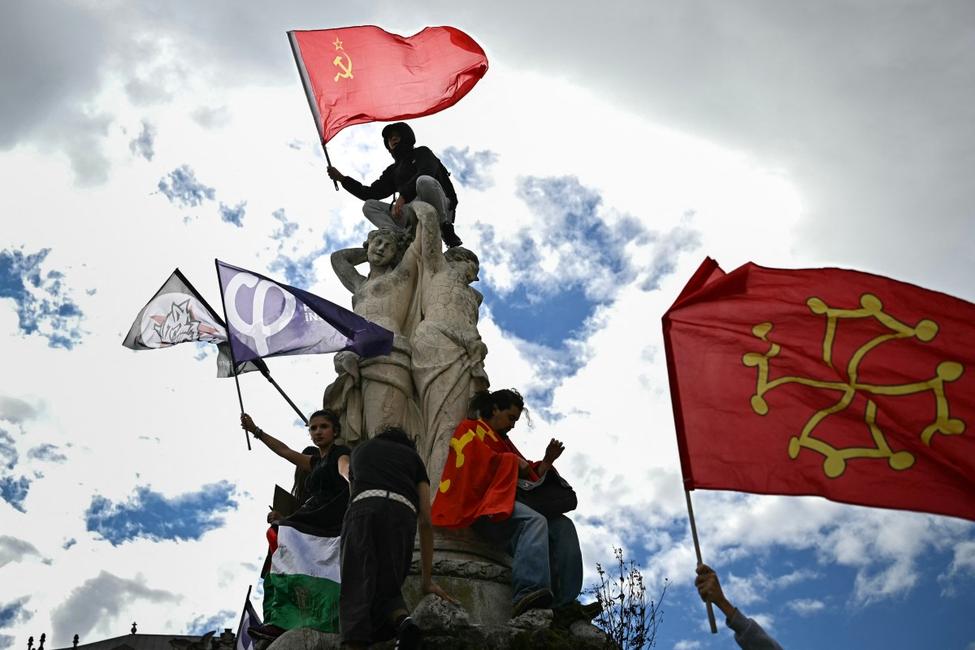 Le 8 octobre 2026, à Montpellier, dans le sud de la France, un manifestant, juché sur une statue, brandit le drapeau de l'Union soviétique lors d'une manifestation de lycéens. Cette action s'inscrit dans un mouvement de protestation national contre les conditions d'apprentissage.