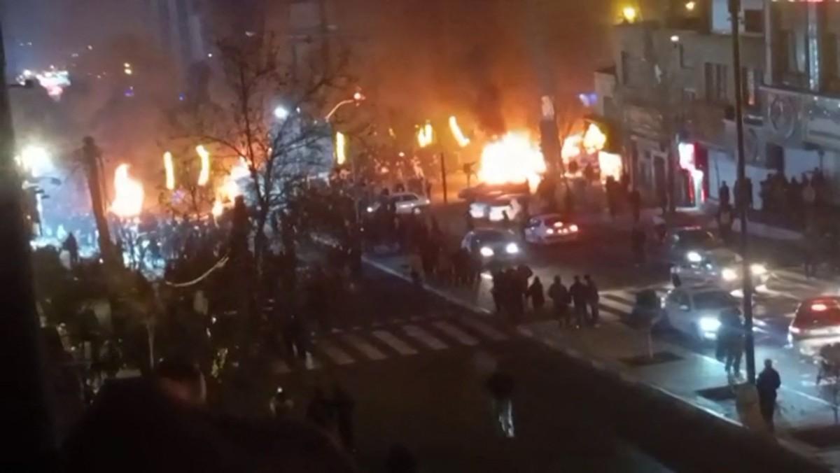 Cette capture d'écran vidéo, réalisée le 14 janvier 2026 à partir d'images UGC publiées sur les réseaux sociaux le 9 janvier 2026, montre des voitures incendiées lors d'une manifestation sur la place Saadat Abad à Téhéran.