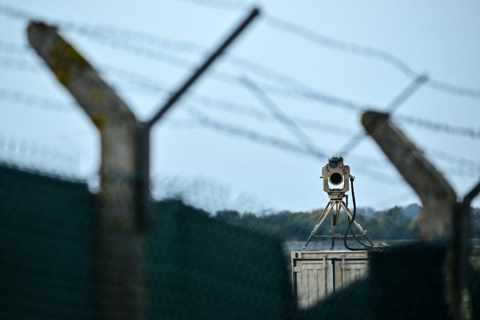 Une caméra de surveillance (à droite) surveille la clôture entourant la base aérienne de Fairford, dans le sud-ouest de l'Angleterre, le 28 septembre 2026, au lendemain d'une enquête menée par la police antiterroriste britannique sur un incident majeur survenu près de cette base utilisée par l'US Air Force.