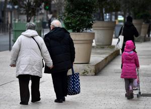 Un couple de personnes âgées marche main dans la main à côté d'une jeune fille à Vincennes, 