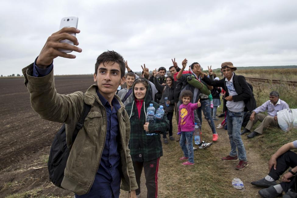 Alvand, 18, from Kobani, Syria takes a selfie with his friends as they walk along a railway track after crossing into Hungary from the border with Serbia near the village of Roszke September 5, 2015.