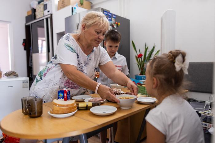 Une femme sert de la soupe à ses petits-enfants dans leur maison de Varsovie.