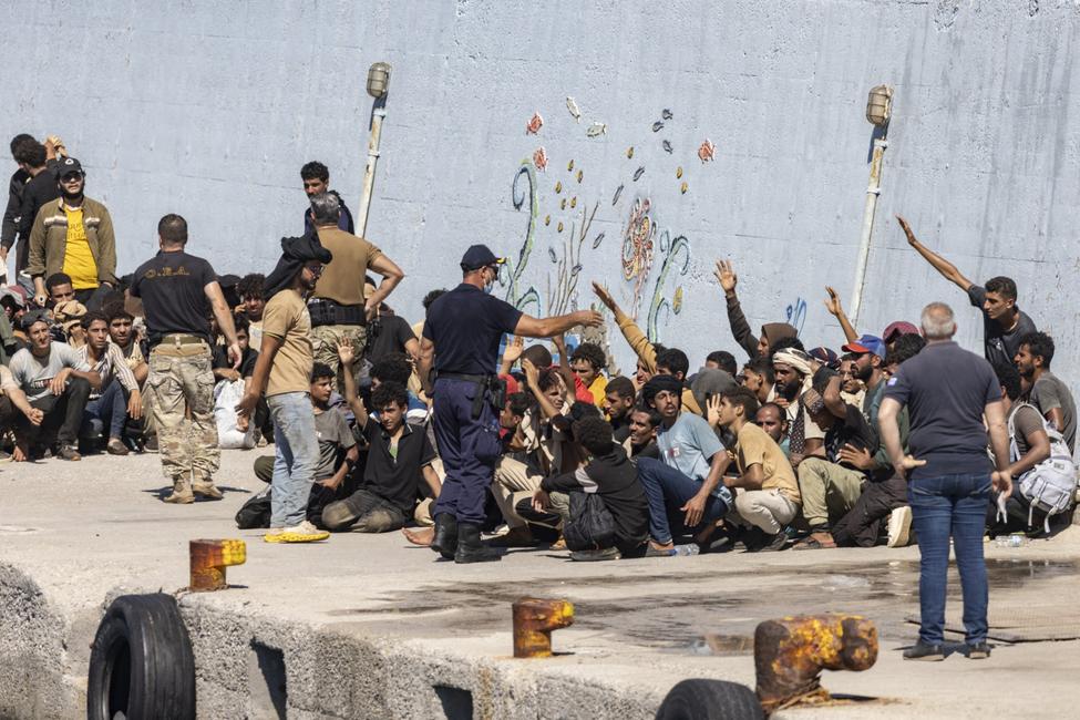 Des migrants secourus en mer au large de l'île grecque de Crète attendent dans le port d'Agia Galini d'être transférés, le 6 juillet 2025.