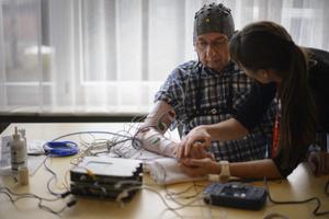 La physiothérapeute Vanessa Buhlmann tient la main d'un patient lors d'une présentation d'une interface cerveau-machine par l'École polytechnique fédérale de Lausanne (EPFL) à Sion.
