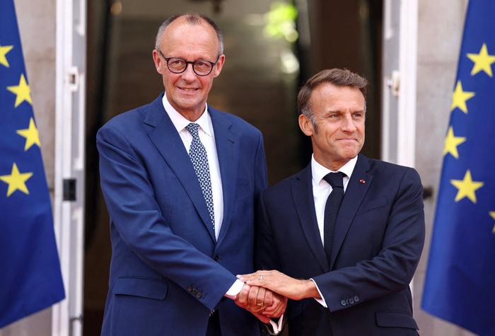 Le président français Emmanuel Macron (à droite) et le chancelier allemand Friedrich Merz (à gauche) se serrent la main avant une réunion du cabinet franco-allemand à Toulon, dans le sud-est de la France, le 29 août 2025. (Photo de Manon Cruz / POOL / AFP)