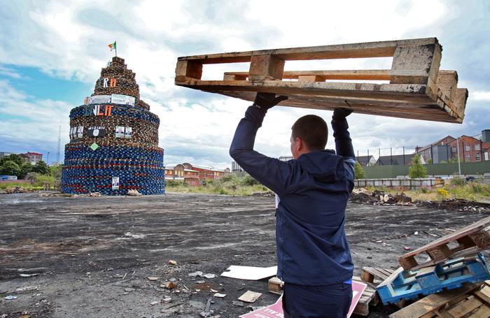 Une palette en bois est transportée vers un feu de joie dans la région de Shankill, à l'ouest de Belfast, en Irlande du Nord.