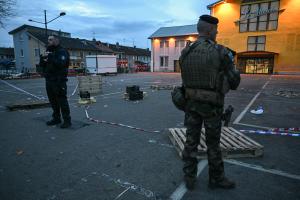 Un policier et un militaire montent la garde sur le lieu d'une attaque à l'arme blanche où un homme est soupçonné d'avoir tué une personne et blessé deux policiers municipaux à Mulhouse, le 22 février 2025.