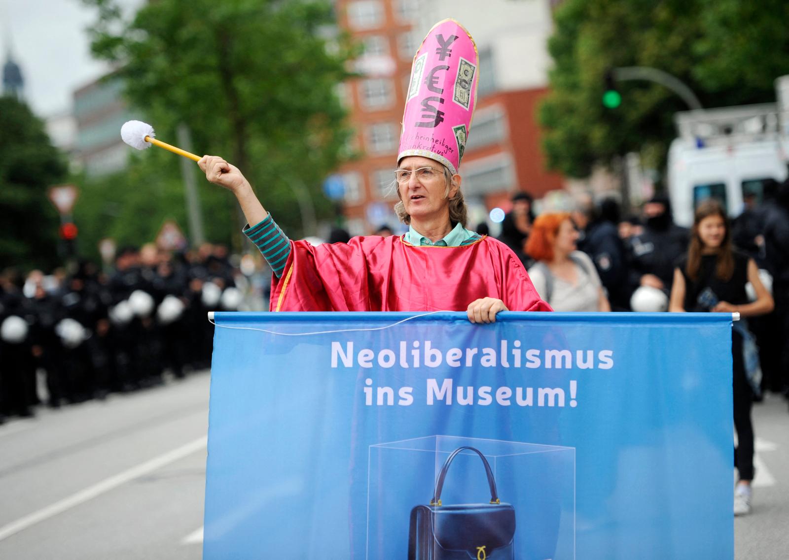 Un manifestant brandit une banderole sur laquelle on peut lire « Le néolibéralisme au musée » lors de la manifestation « Solidarité sans frontières plutôt que le G20 », le 8 juillet 2017 à Hambourg, dans le nord de l’Allemagne, alors que les dirigeants mondiaux se réunissent à l’occasion du sommet du G20. (Image d'illustration)