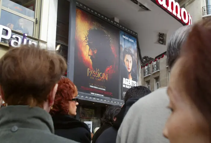 Des personnes patientent devant un cinéma, le 11 avril 2004 à Paris, pour assister à une séance de "la Passion du Christ", du réalisateur australien Mel Gibson.