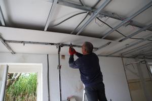 Un artisan installe un faux plafond en vue de la pose d'une isolation thermique dans une maison à Cognocoli-Monticchi, en Corse.