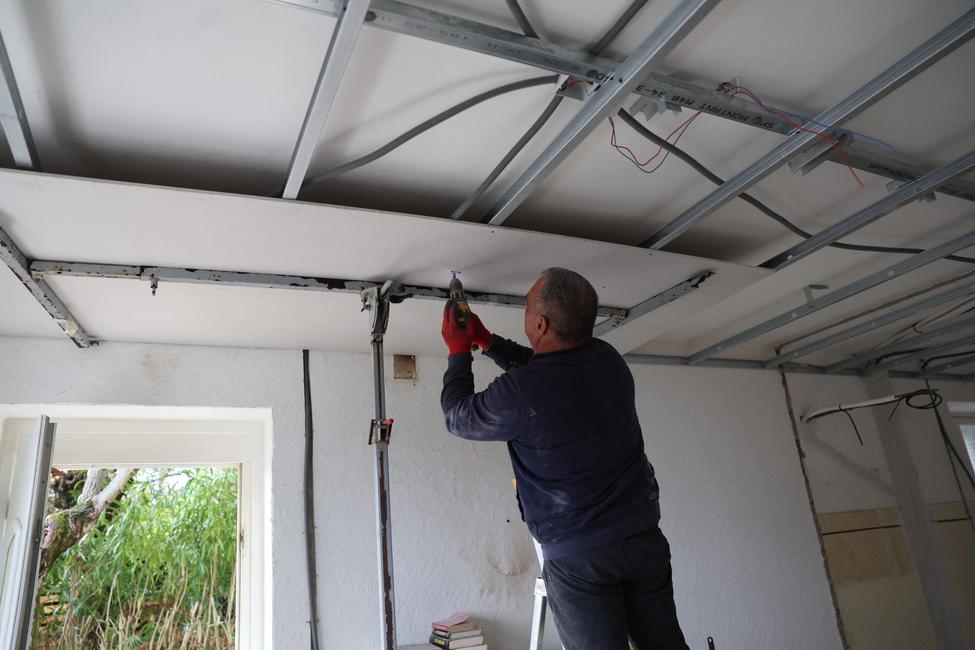 Un artisan installe un faux plafond en vue de la pose d'une isolation thermique dans une maison à Cognocoli-Monticchi, en Corse.