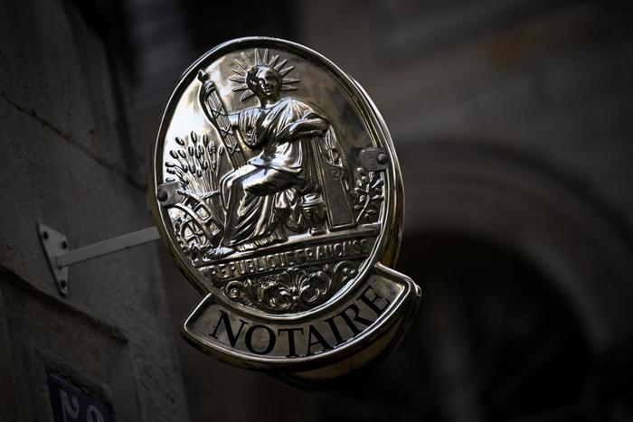 Une enseigne de notaire sur un immeuble de bureaux, officiellement désigné par le ministère de la Justice, dans une rue du centre de Paris.