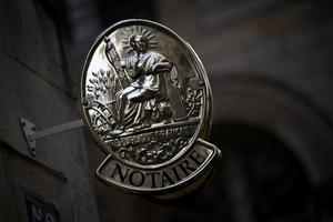 Une enseigne de notaire sur un immeuble de bureaux, officiellement désigné par le ministère de la Justice, dans une rue du centre de Paris.